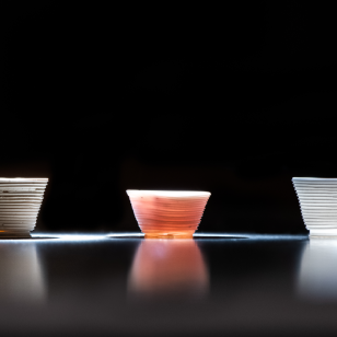 Researchers used the low-temperature additive manufacturing process to build the glass cups above. The optical behavior of the printed cups can be tailored by altering the chemical components of the inks.