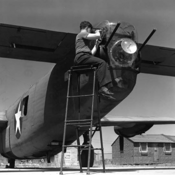 An ASG airborne fire-control radar is installed by a Rad Lab technician in the rear of a gun turret of a B-24. Photo: MIT Museum.