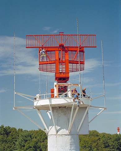 A photo of an orange radar antenna. 