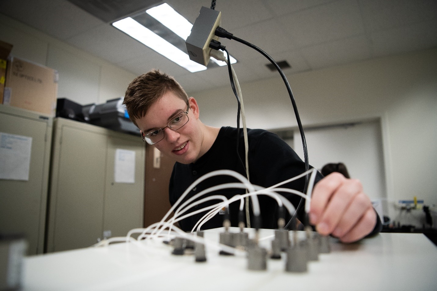 Andrew O'Brien adjusts transducers in a laboratory