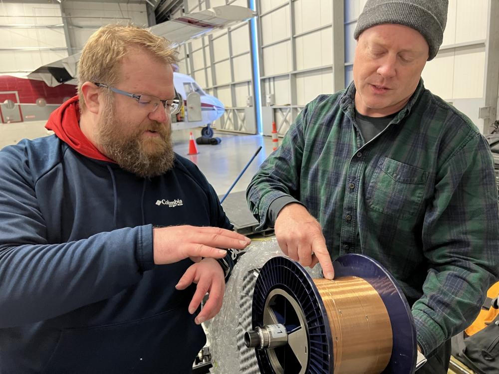 Lincoln Laboratory’s Ben Evans (left) and Dave Whelihan deployed this spool — featuring 230 feet of polymer fiber with embedded temperature and depth sensors — in the Arctic. Photo: U.S. Navy Lt. Seth Koenig.