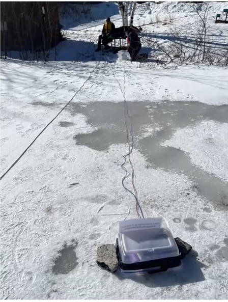 The researchers placed a seismometer inside a buoyant housing enclosure on the ice at Firepond. 