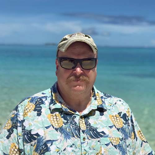 A portrait photograph of John O'Rourke, with the ocean in the background.