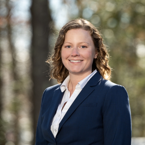 A portrait photograph of Kat Riesing outdoors in wooded environment.