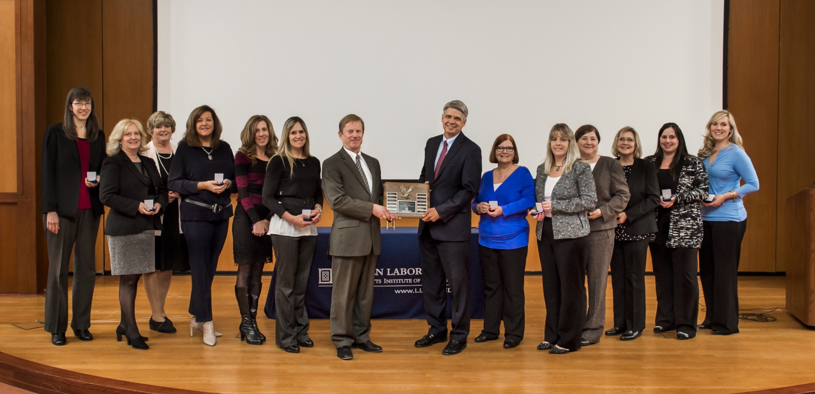 Shawn Daley, Head of Security Services, and Eric Evans, Director, received a plaque from the U.S. Air Force recognizing the Laboratory's 11th Superior security rating. Also photographed are representatives of groups audited during the security review.