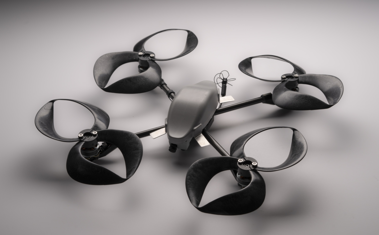 A small commercial drone outfitted with four toroidal propellers (each propeller looks like two loops, made of plastic).
