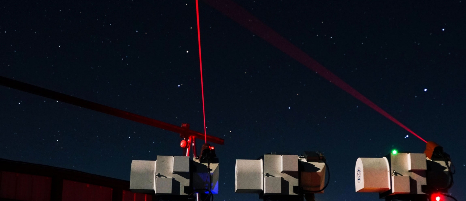 A photo of three lasers being transmitted from ground modules