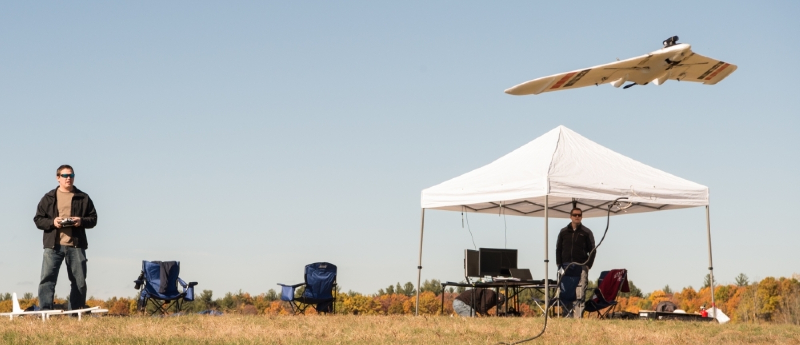 a person flying a small UAV in a field