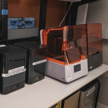 A photo of five small 3d printers on a desk. 