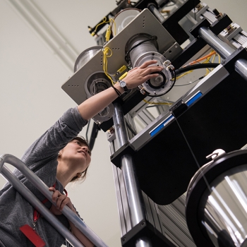 Lauren Cantley, a postdoctoral associate in the Chemical, Microsystem, and Nanoscale Technologies Group, adjusts the fiber draw tower as it pulls and spools a fiber.
