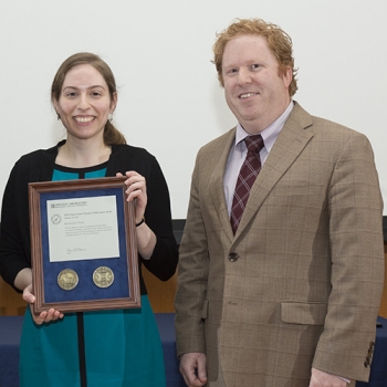 Emily Fenn, with her citation, is joined by Marc Viera, Assistant Head, Intelligence, Surveillance, and Reconnaissance and Tactical Systems Division, who gave introductory remarks for her award. Photo: Glen Cooper