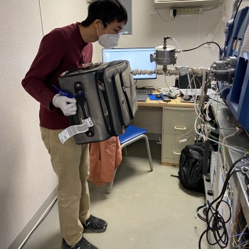 Ta-Hsuan Ong measures concealed explosives by holding a suitcase up to the mass spectrometer. Photo: Lincoln Laboratory