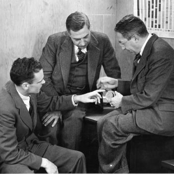 E. G. Bowen, left, is shown an American-made copy of the cavity magnetron by Radiation Laboratory director L. A. DuBridge, center, and associate director I. I. Rabi, a Nobel Prize winner, right. Photo: MIT Museum - Radiation Laboratory Negative Collection