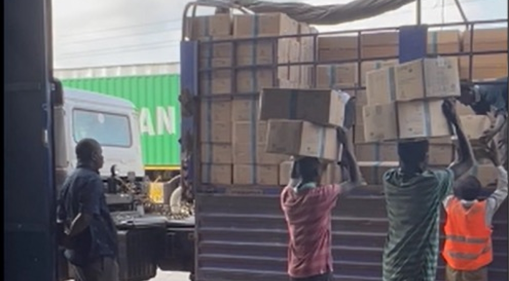 Porters in Kenya carry boxes of Super Cereal Plus atop their heads.