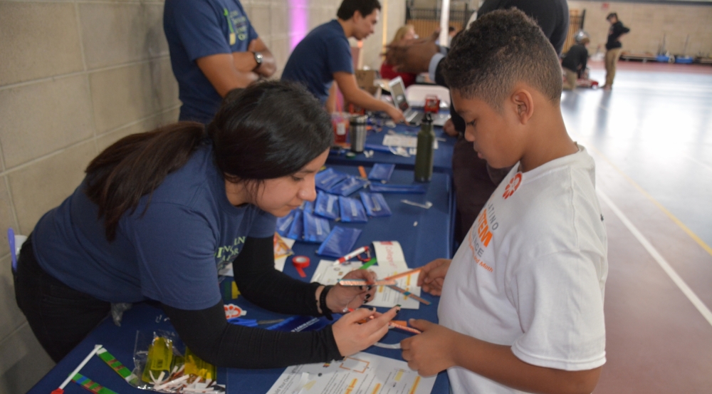 A Laboratory volunteer helps a student to construct a lightsaber. 