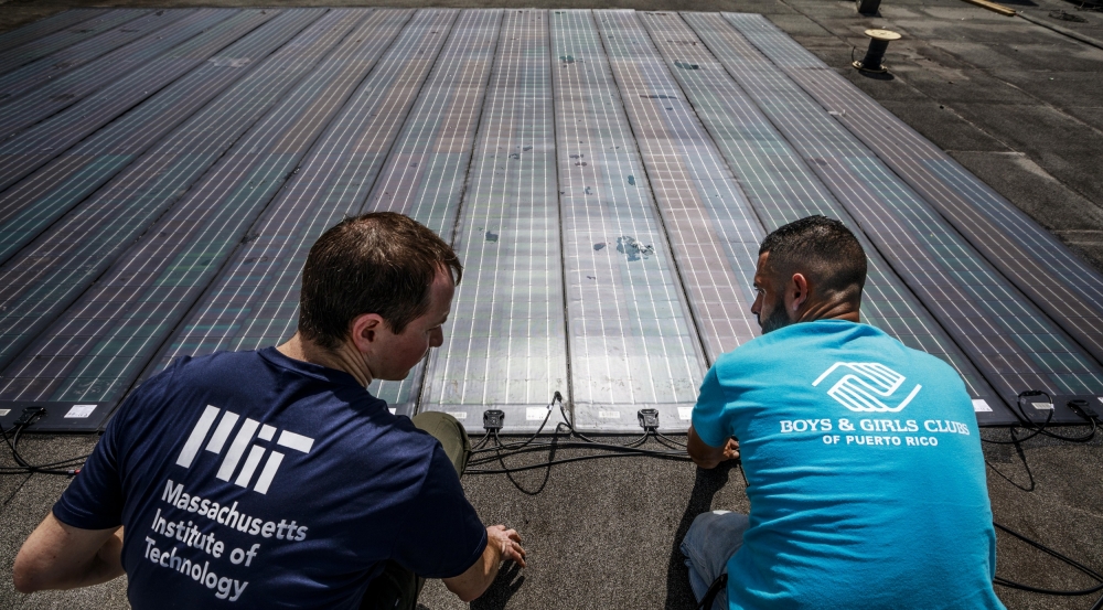Erik Limpaecher, left, leader of the Energy Systems Group and a co-author on the report, is shown helping to install solar panels for a water purification system at the Boys and Girls Clubs of Puerto Rico in 2017. Photo: Lorenzo Moscia