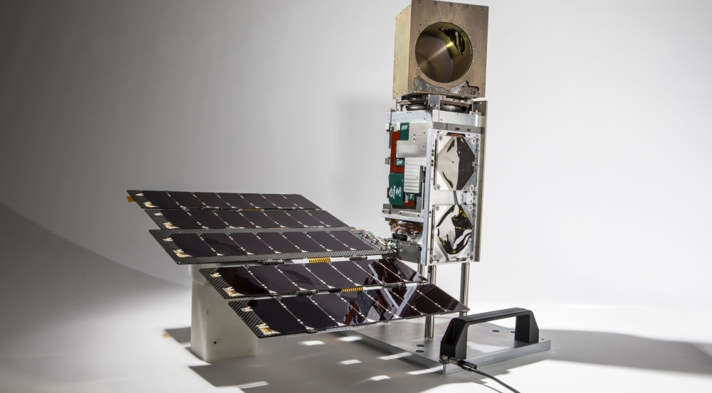 The TROPICS small satellite is shown with its solar panel unfurled. The satellite is about the size of a half gallon of milk.
