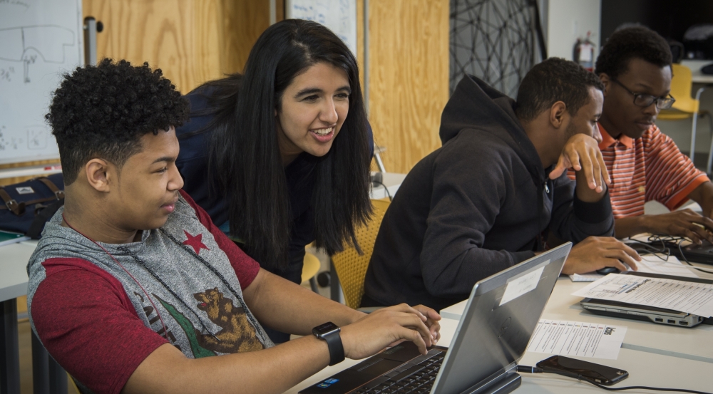 Laboratory staff connect with students while teaching coding exercises.