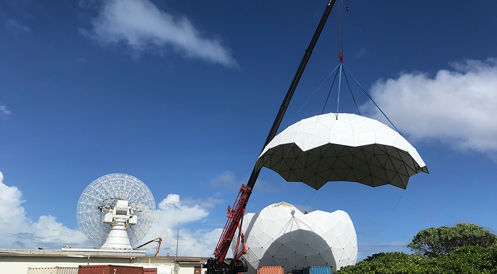 The top cap of the new ALCOR radome is lifted into place.  