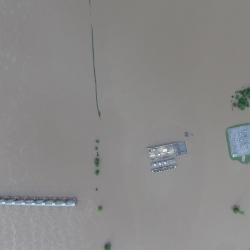 aerial photo of a flooded area with building roofs visible. 
