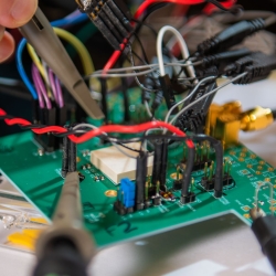 A close up photo of an integrated circuit board with connected wires. 