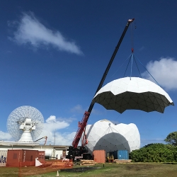 The top cap of the new ALCOR radome is lifted into place.  