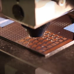 a close-up view of a 3D printer head depositing material.