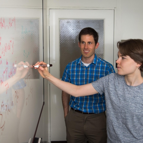 As mentor Henry Romero looks on, UROP student Gabriela Studt does calculations to compare soft-decision decoding algorithms for Reed-Solomon error-correcting codes.