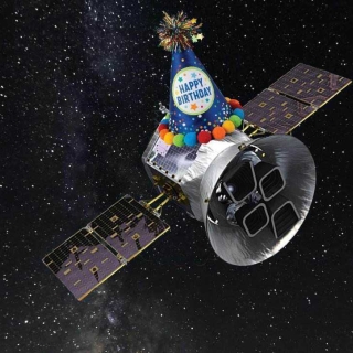 A satellite with a happy birthday hat flies through space.