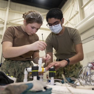Cadets Rodrigue and Padmanaban mount their motor to their underwater vehicle.