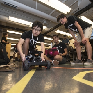 Students in the Beaver Works Summer Institute practice steering their self-programmed robotic racecars, a challenge that included using the robots' sensors, programmed to detect a lane marking. 