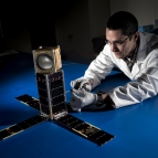 Mike DiLiberto leanes next to the MicroMAS-2A cubesat.