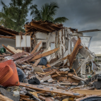 A house is shown destroyed and reduced to rubble. 