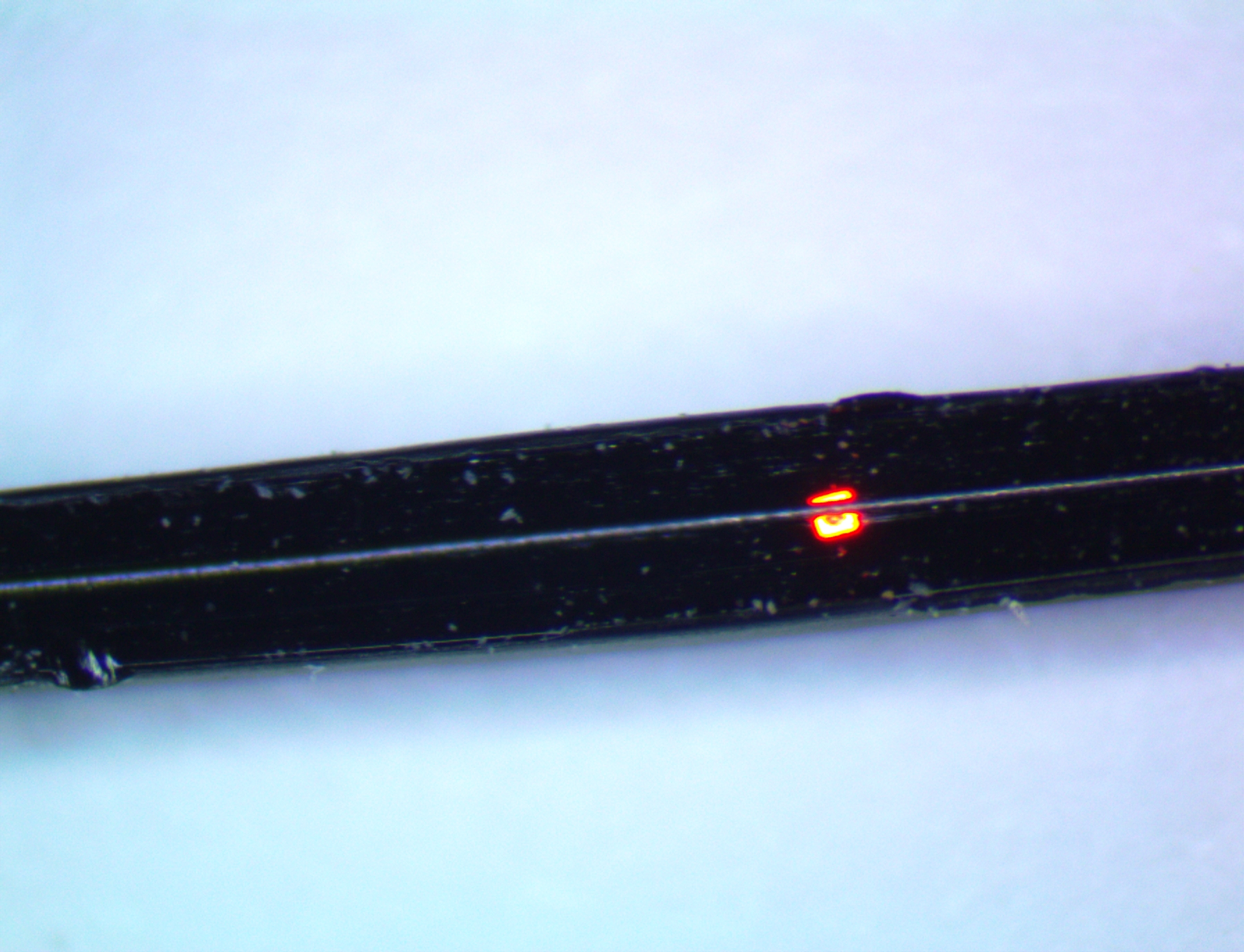 a close up image of a fiber with a red LED embedded into it. 