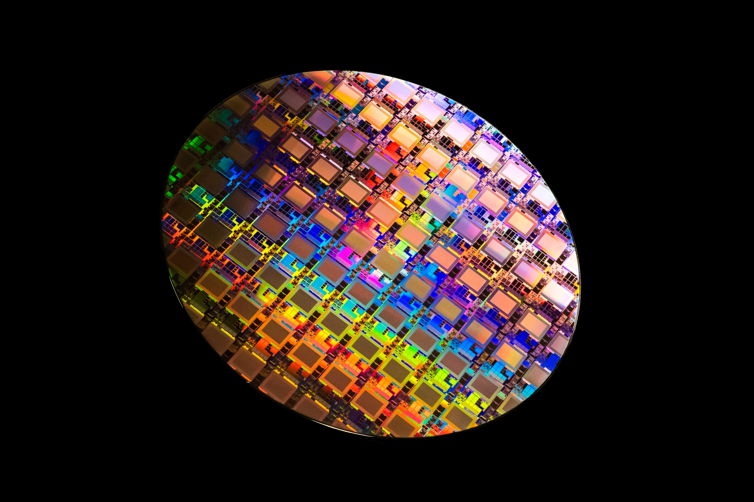 A photo of a multicolored wafer containing integrated circuits. 