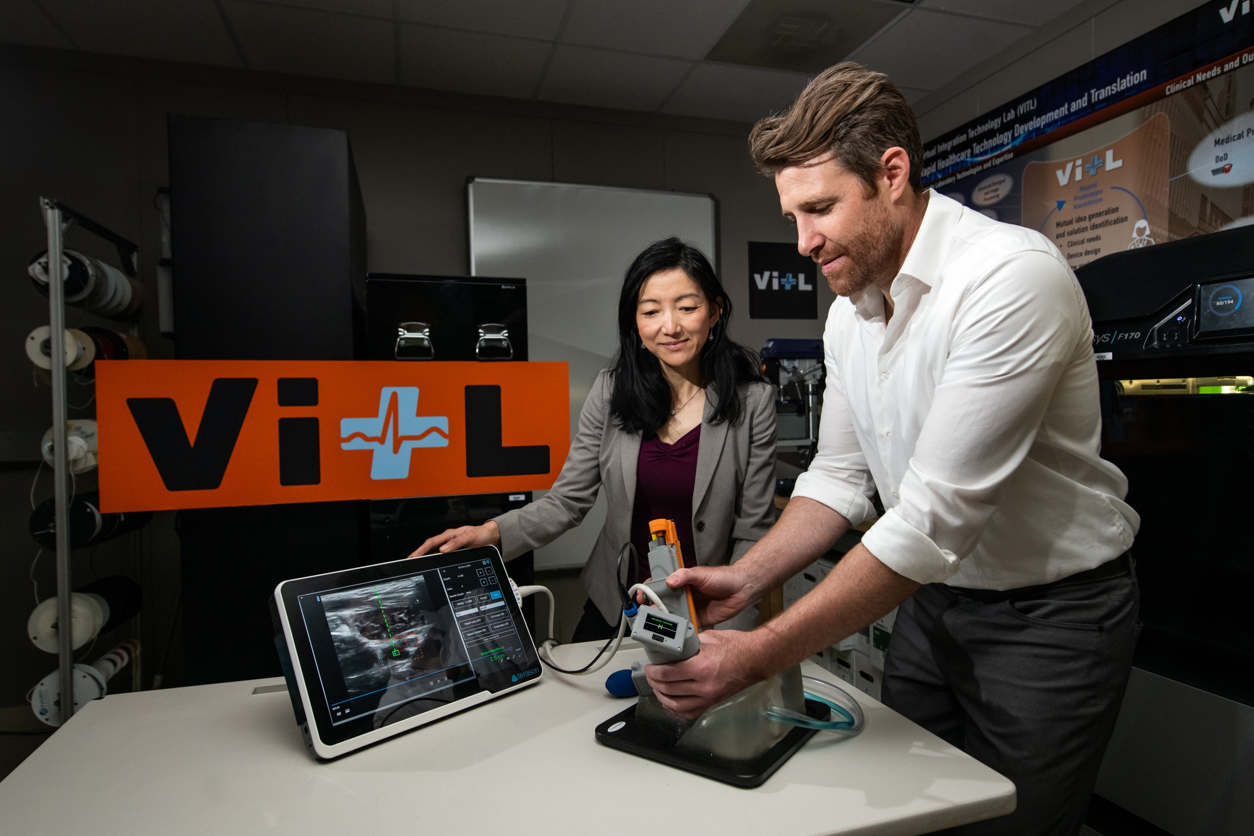 Research team members Matt Johnson and Laura Brattain test their new medical device on an artificial model of human tissue and blood vessels.