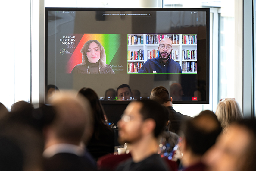 A screen shows Clint Smith III, a nationally recognized poet and educator, and moderator Bonnie Walker, the Laboratory's principal diversity and inclusion officer.