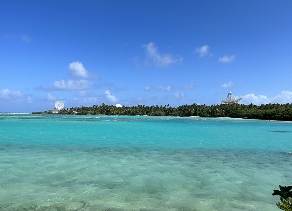 An ocean view shows three radars in the background.