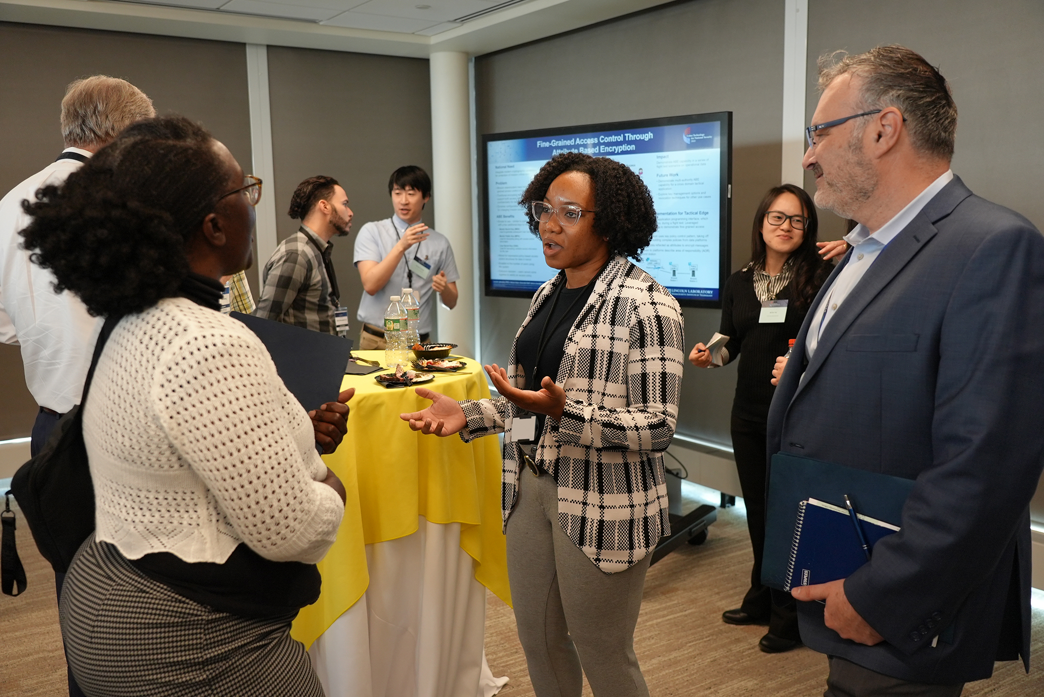 three people talking around a high top table at a poster session