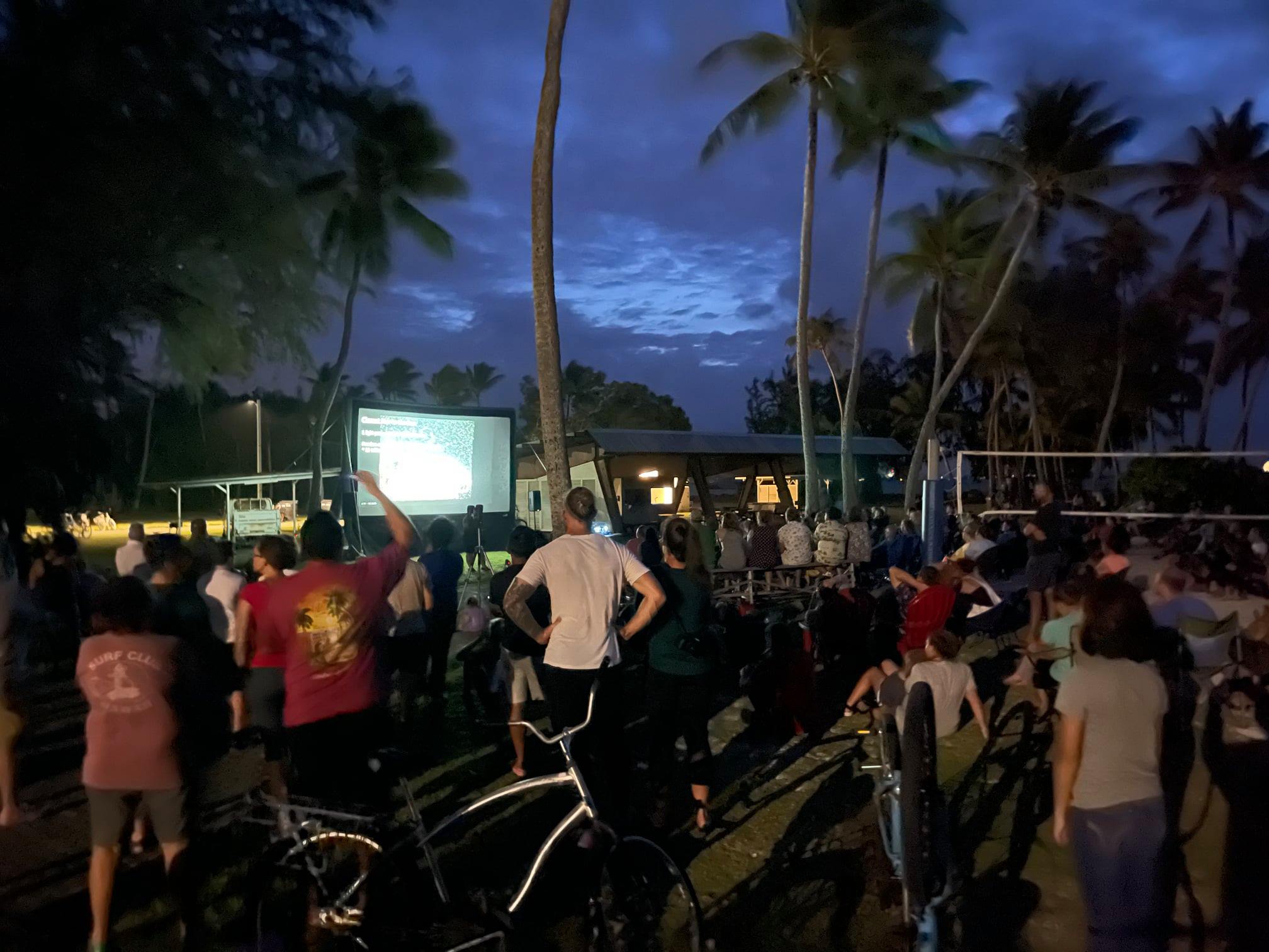 People gather outside at night for an astronomy talk. 