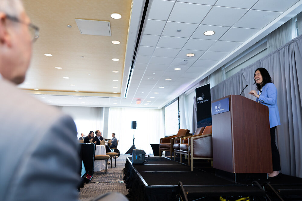 Evelyn Wang, MIT Vice President for Energy and Climate, presents from the a podium at the front of a room of attendees.