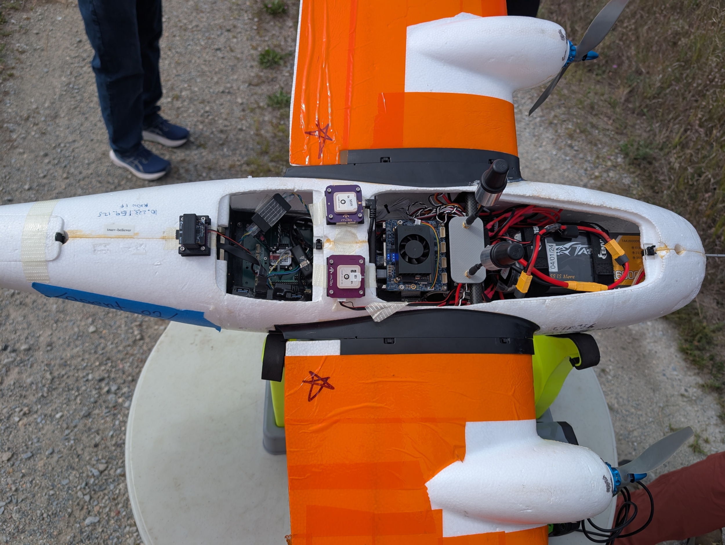 A view of the team's autonomous vehicle from above with the top panel open to show inside components such as the battery, the autopilot, and GPS sensor. 