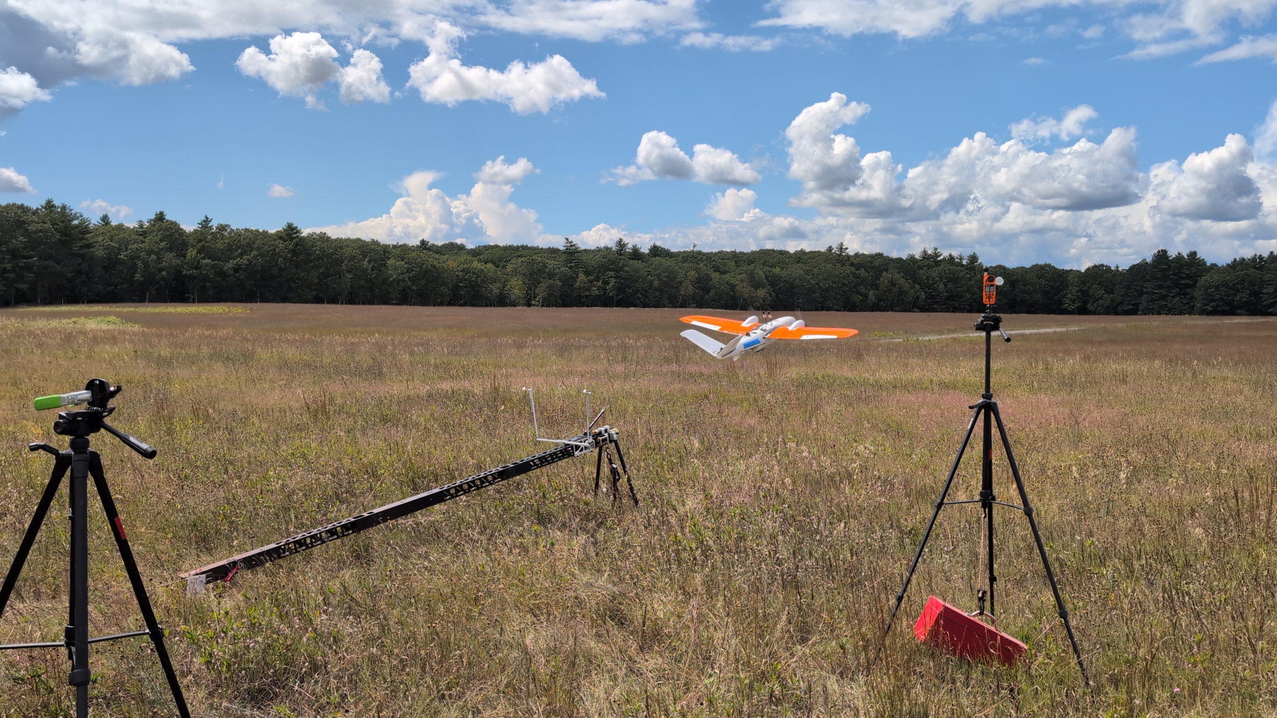The research team's data collection drone is being launched from a ramp in a field on a clear day. 
