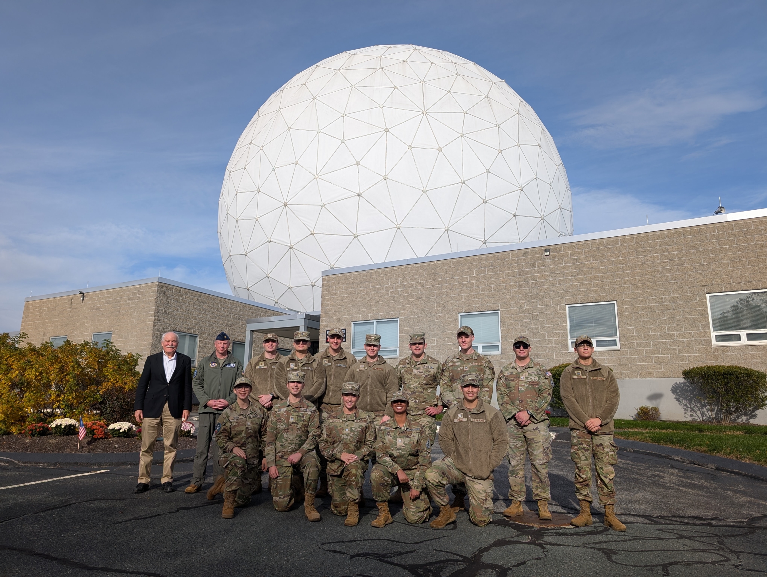 14 Air Force ROTC cadets pose for a photo in front of the HUSIR radar antenna radome. 