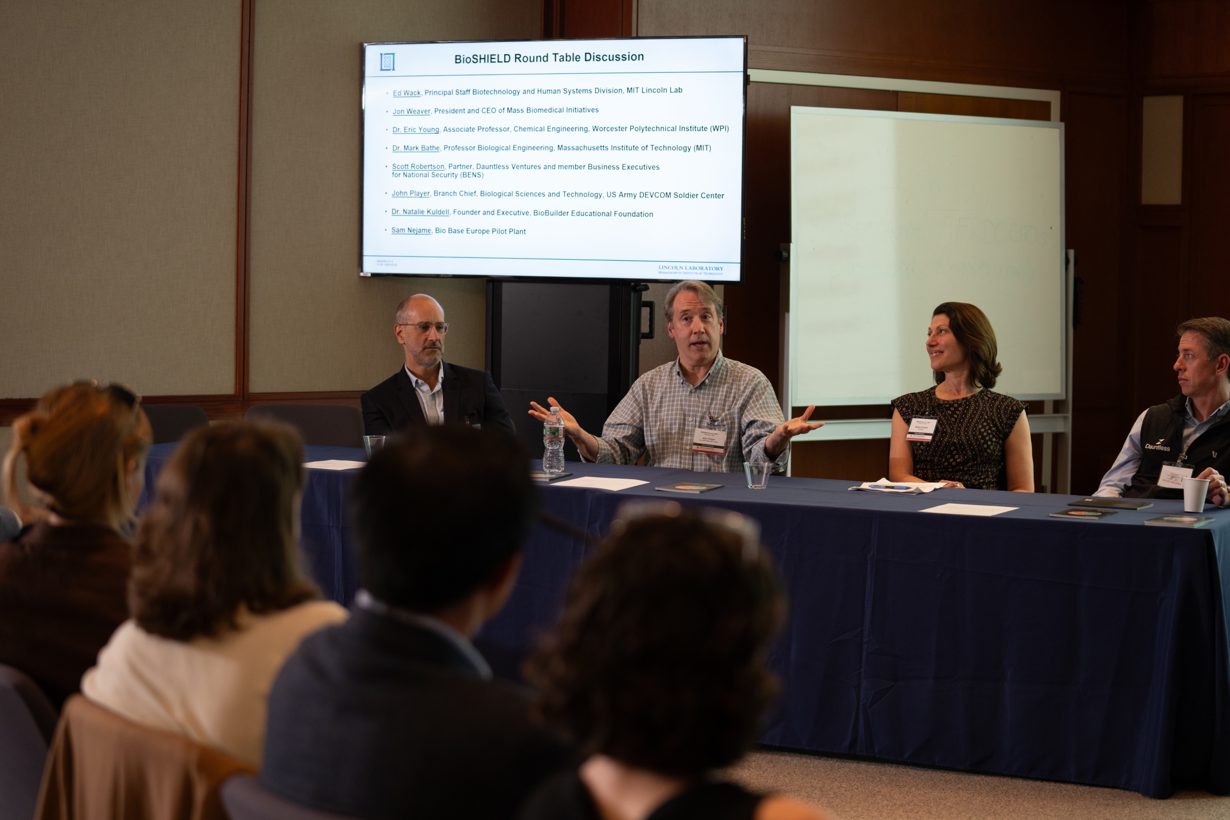 A group of four panelists at a table in discussion