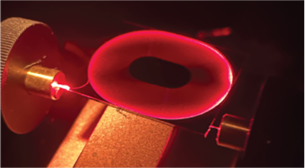 A photograph of the scatter out of the spiral delay line when red light is sent through the input port.