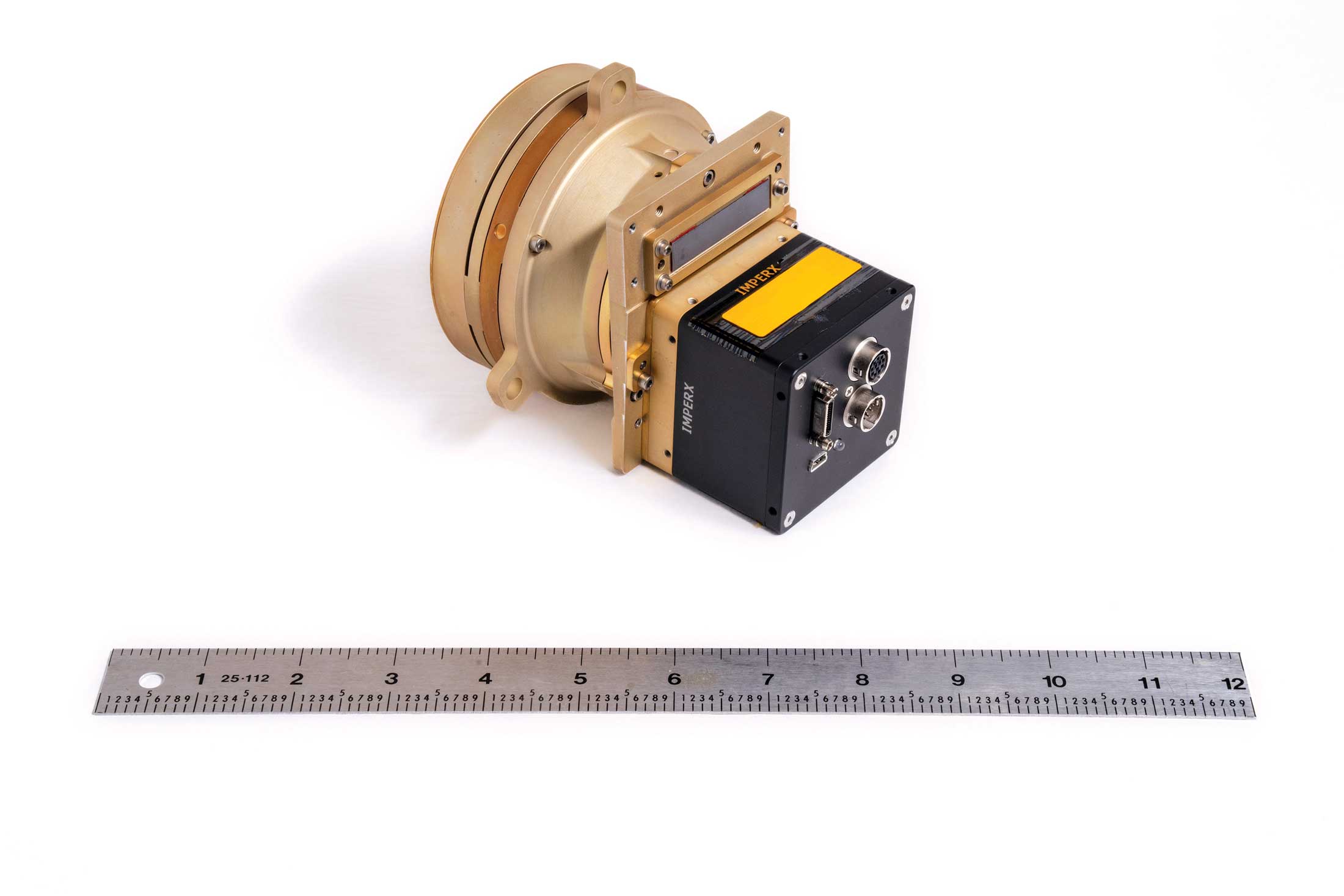 Photo of the prototype of the Chrisp Compact VNIR/SWIR Imaging Spectrometer with ruler beneath for scale.