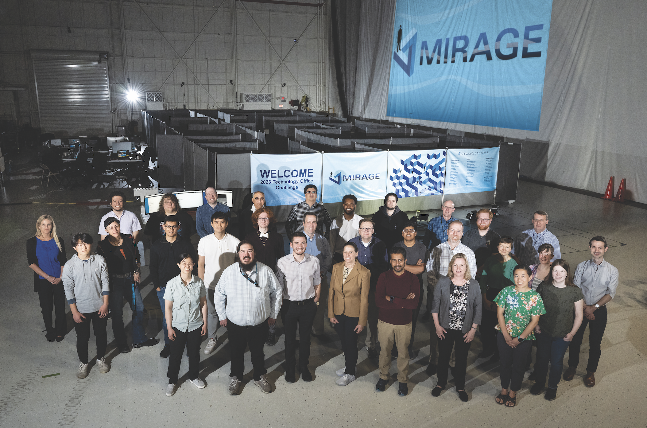 A group of researchers pose for a group photo in front of a makeshift maze