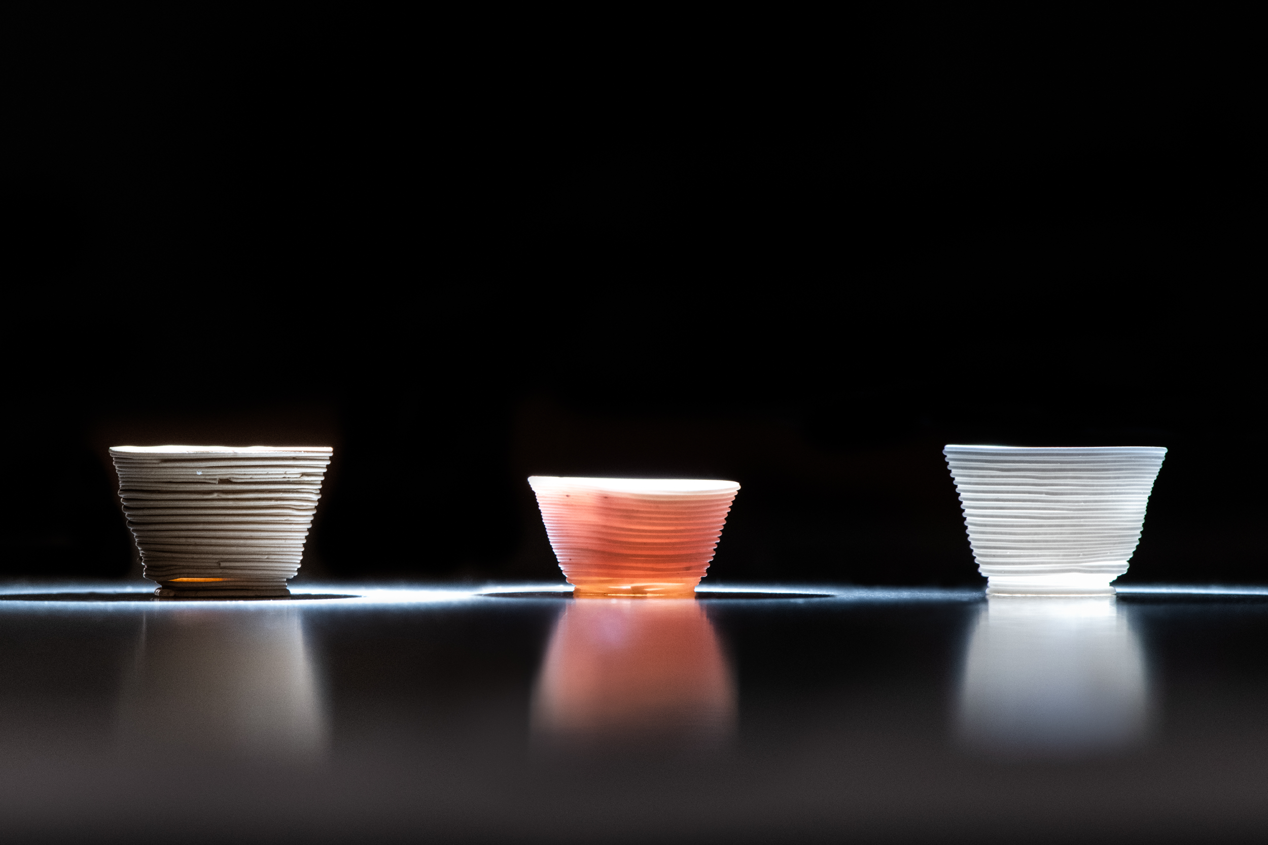 Researchers used the low-temperature additive manufacturing process to build the glass cups above.   The optical behavior of the printed cups can be tailored by altering the chemical components of the inks. 