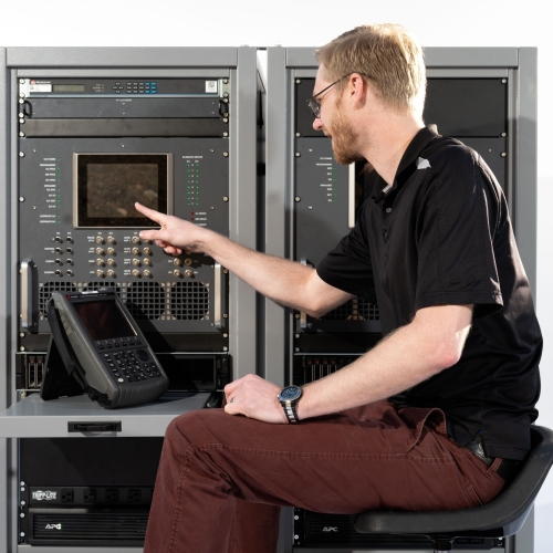 An individual sitting in front of a test terminal presses a button.